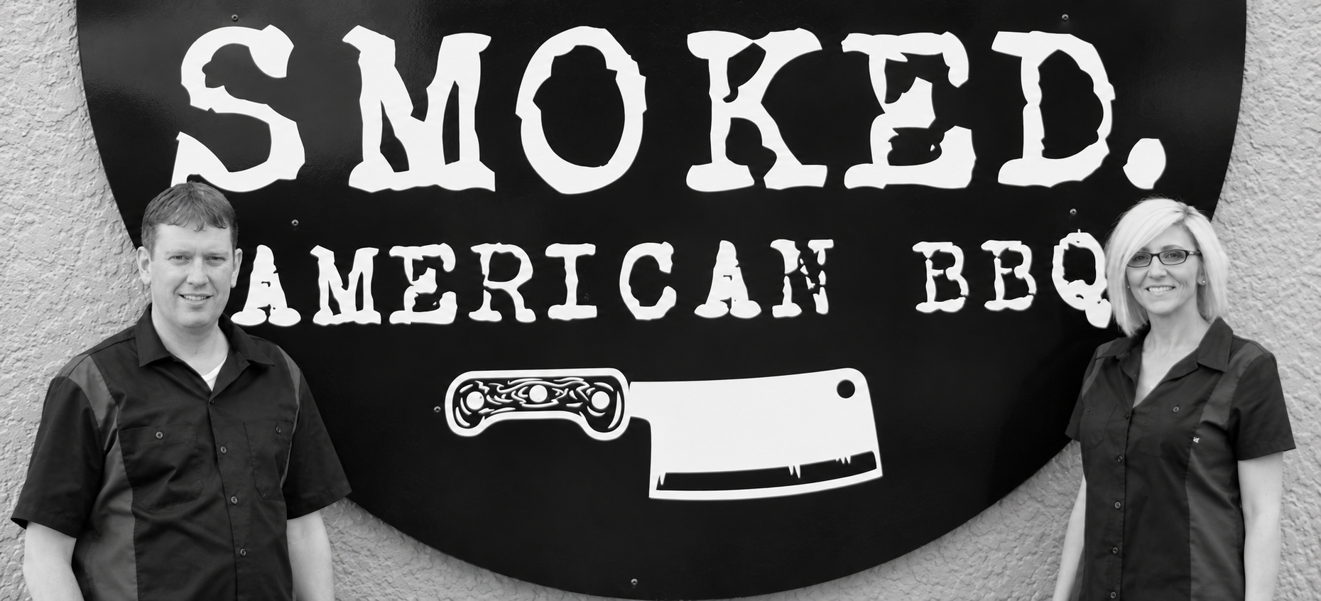SMOKED. owners Trevor and Christy Cavanagh standing beside their restaurant sign